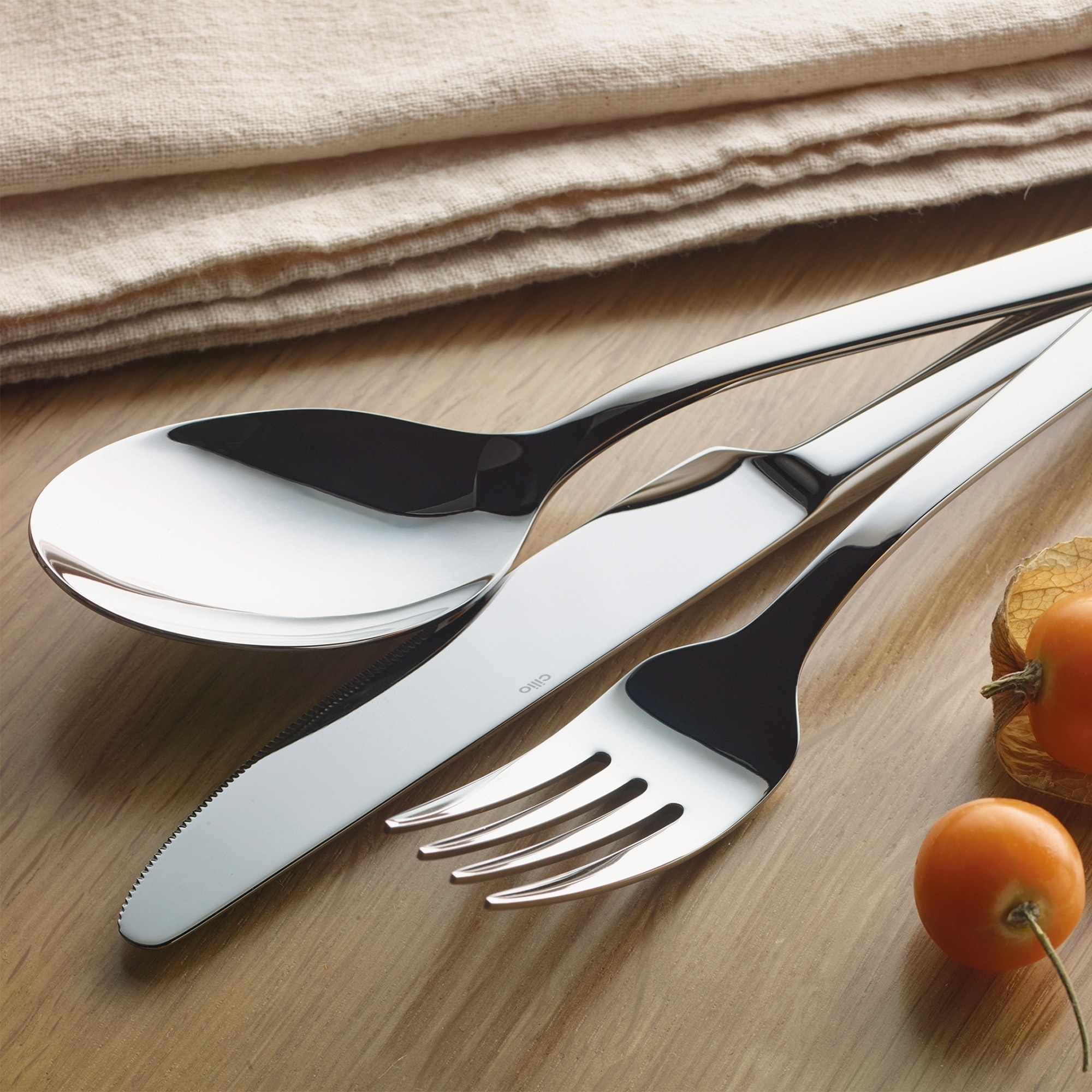 Modern stainless steel cutlery set on wooden table